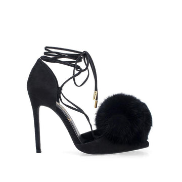 Women's Black colored high heel pumps with faux fur pom on head and ankle wrap lace up-side view