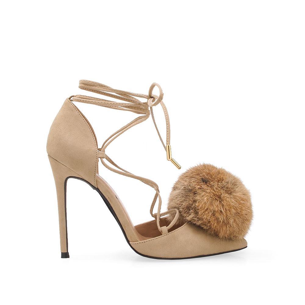 Taupe-colored high-heeled pumps for women with an ankle wrap lace up and front faux fur pom-side view