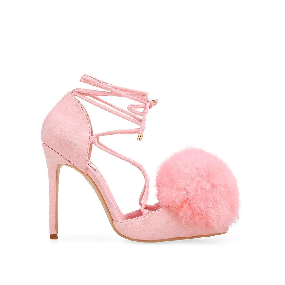 Women's pink-colored high heel pumps with faux fur pom on top and ankle wrap lace up-side view