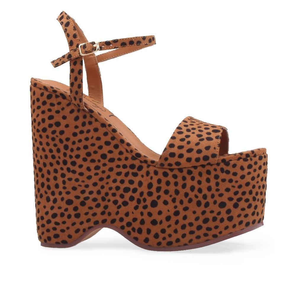 Slip-on wedge shoes with cheetah print and an ankle buckle clasp.